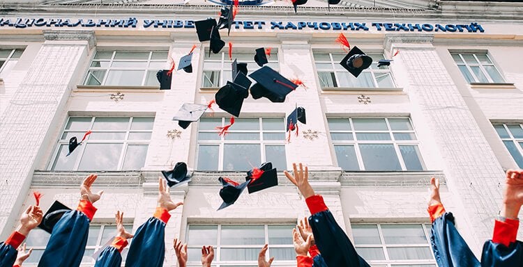 Graduates throwing mortarboards in the air