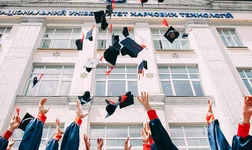 Graduates throwing mortarboards in the air