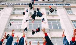 Graduates throwing mortarboards in the air