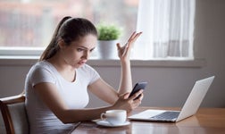 Woman in white top distressed by scam
