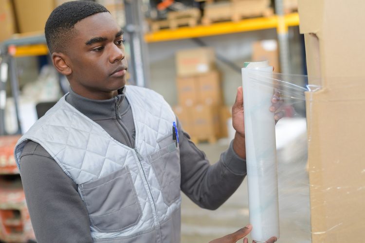 Man shrink wrapping a box