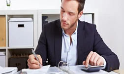 Man in blazer going through a ring binder