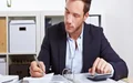 Man in blazer going through a ring binder