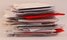 A stack of letters with envelopes of various colours