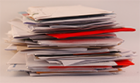 A stack of letters with envelopes of various colours