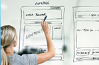 Woman writing out wireframe for a webpage design