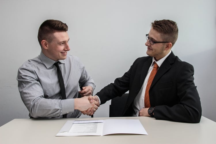 Senior employee and new employee shaking hands
