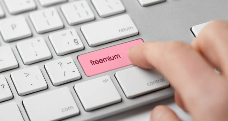 Person pressing button on keyboard that reads 'freemium'