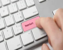 Person pressing button on keyboard that reads 'freemium'