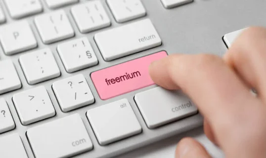 Person pressing button on keyboard that reads 'freemium'