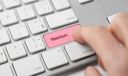 Person pressing button on keyboard that reads 'freemium'