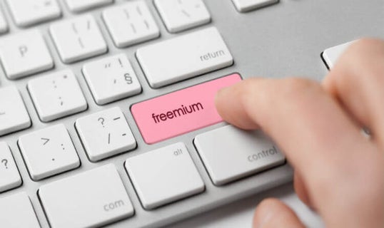 Person pressing button on keyboard that reads 'freemium'